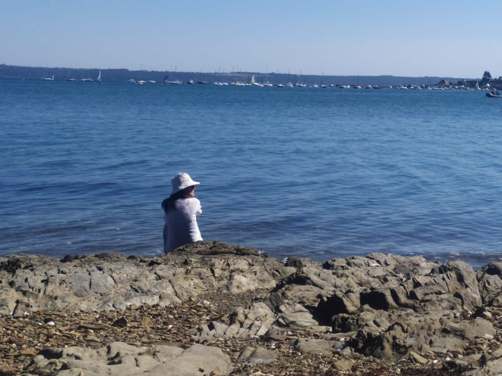 Une personne au bord de l'eau symbolisant une femme dont on ne sait rien