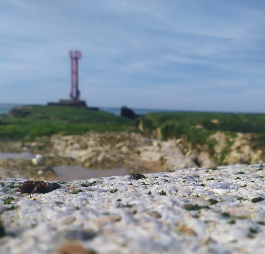 photo de la plage oeil tourné vers un phare métaphore de l'objectif que l'on se donne