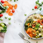image d'un dessus de table sur laquelle il y a des légumes de différentes couleurs et une assiette composée de ceux-ci pour représenter l'alimentation saine