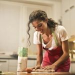 une femme est en train de cuisiner en souriant pour représenter le fait que j'aime cuisiner