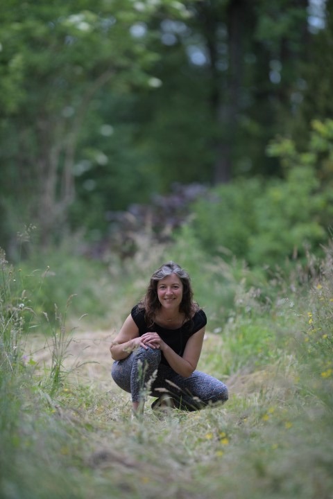 image couleur de sandra marchand accroupie dans la nature face objectif