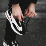 une personne est en train de lasser ses chaussures de sport symbolisant l activité sportive